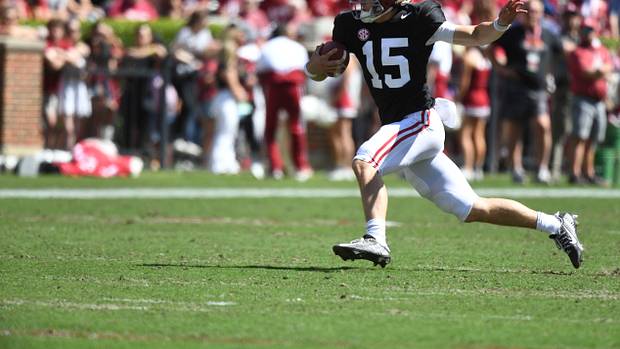 Alabam Crimson Tide quarterback Ty Simpson carries the ball.
