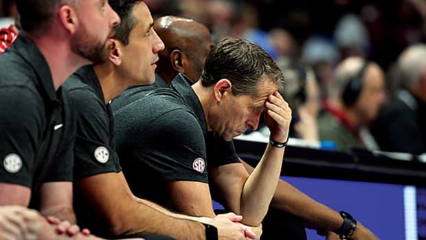 Arkansas Razorbacks head coach Eric Musselman hangs his head on the bench late in the second half of a loss against the Texas A&M Aggies.