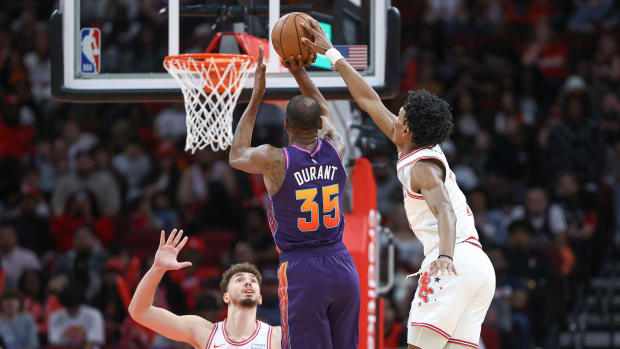 Rockets forward Amen Thompson (1) attempts to block a shot by Phoenix Suns forward Kevin Durant (35) during the second quarter at Toyota Center.