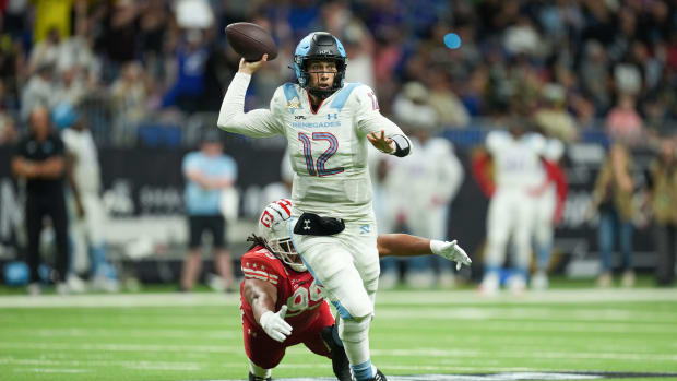 May 13, 2023; San Antonio, TX, USA; Arlington Renegades quarterback Luis Perez (12) throws a pass as DC Defenders defensive lineman Joe Wallace (99) reaches for his feet in the first half at the Alamodome. Mandatory Credit: Daniel Dunn-USA TODAY Sports  