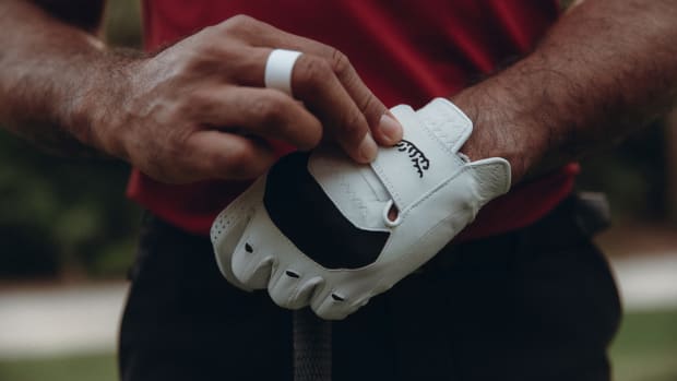 Tiger Woods models a white Sun Day Red golf glove.