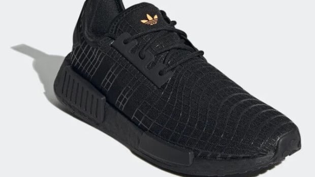 Side view of black adidas sneakers.