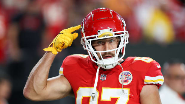 Travis Kelce points to his helmet during a game.