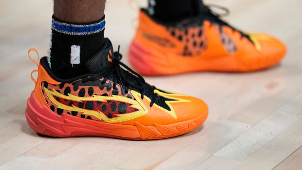 Portland Trail Blazers guard Scoot Henderson's orange and black PUMA sneakers.