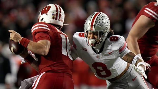 Wisconsin quarterback Braedyn Locke (18) avoids a sack by Ohio State safety Lathan Ransom (8) during the second quarter of their game Saturday, October 28, 2023 at Camp Randall Stadium in Madison, Wisconsin