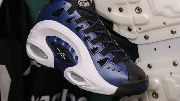 Side view of blue, black, and white Reebok shoes.