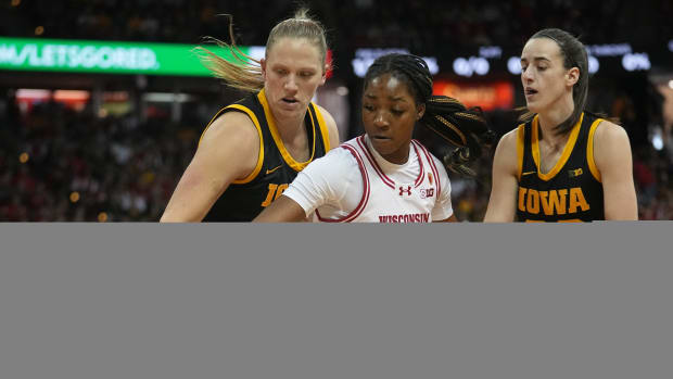 Wisconsin forward Serah Williams (25) is double-teamed Iowa center Sharon Goodman (40) and guard Caitlin Clark (22) during the first half of their game Sunday, December 10, 2023 at the Kohl Center in Madison, Wisconsin.  