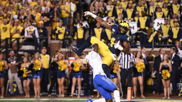 Nico Collins catches a touchdown pass as Blue Raiders safety Gregory Grate Jr attempts to break up the play during the second quarter at Michigan Stadium