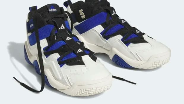 Side view of blue, black, and white adidas sneakers.