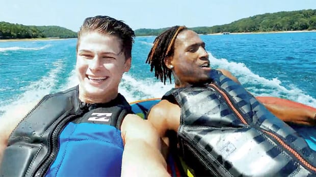Arkansas basketball players Lawson Blake and Jeremiah Davenport ride on a tube pulled by a boat on a team outing with coach Eric Musselman at a Northwest Arkansas lake.