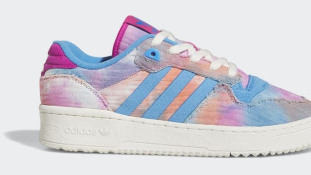 Side view of a pink and blue adidas shoe.