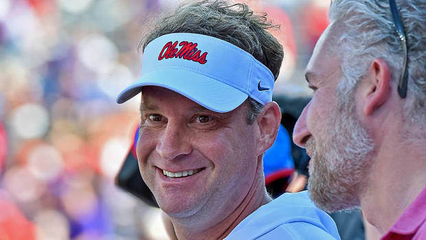 Lane Kiffin smiles while on the sideline during a blowout loss to Arkansas.