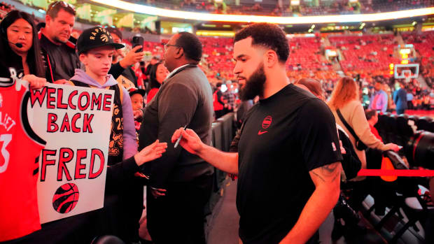 Rockets guard Fred VanVleet (5) goes to sign an autograph for a fan before a game against the Toronto Raptors at Scotiabank Arena.