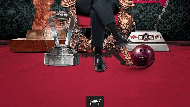Sam Pittman sits on a throne surrounded by all the trophies his Razorbacks won in 2021, along with Larry the Bowling Ball.
