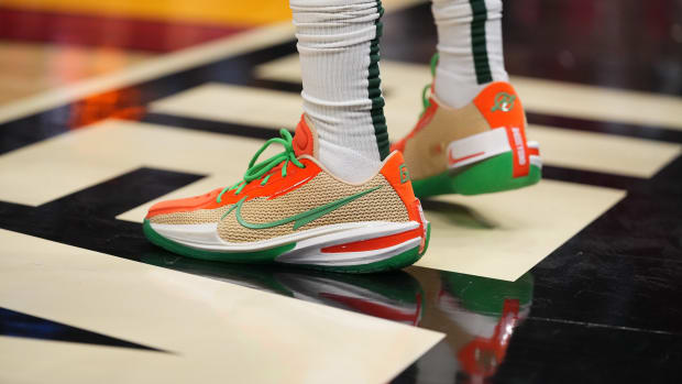 View of tan, green, and orange Nike shoes.