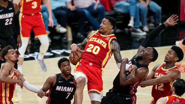 Apr 22, 2022; Atlanta, Georgia, USA; Atlanta Hawks forward John Collins (20) fights for a rebound with Miami Heat guard Kyle Lowry (7) and center Bam Adebayo (13) during the second half during game three of the first round of the 2022 NBA playoffs at State Farm Arena.