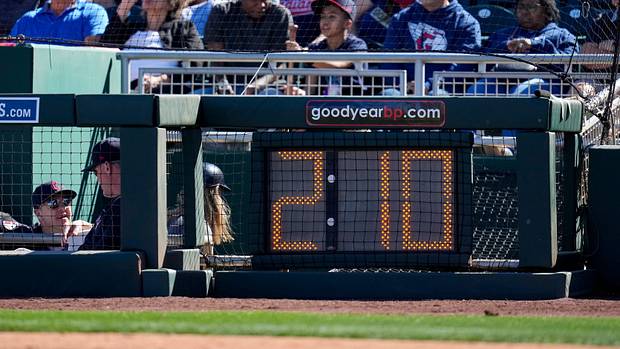 The newly installed pitch clock is lit behind the plate in the third inning of the MLB Cactus League spring training game between the Cincinnati Reds and the Cleveland Guardians at Goodyear Ballpark in Goodyear, Ariz., on Saturday, Feb. 25, 2023. Cleveland Guardians At Cincinnati Reds Spring Training