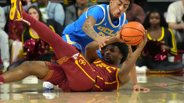 USC Trojans guard Bronny James and UCLA Bruins forward Devin Williams battle for a loose ball.