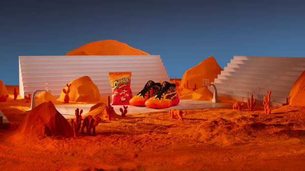 Scoot Henderso's orange and black PUMA shoes next to a Cheetos bag.