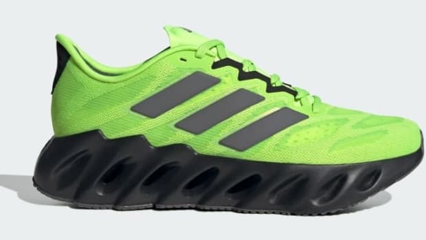 Side view of a green and black adidas shoe.