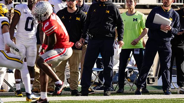 Michigan Wolverines head coach Jim Harbaugh watches from the sideline beside off-field analyst Connor Stalions, right, during the NCAA football game against the Ohio State Buckeyes at Ohio Stadium