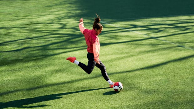 Kelley O'Hara kicks a soccer ball.
