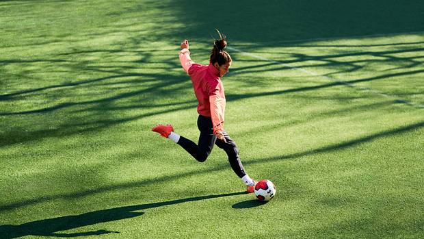 Kelley O'Hara kicks a soccer ball.