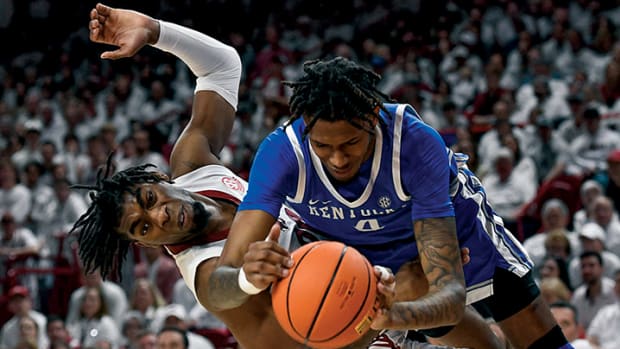 Arkansas Razorbacks Kamani Johnson tries to get the ball from Kentucky Wildcats Daimion Collins.