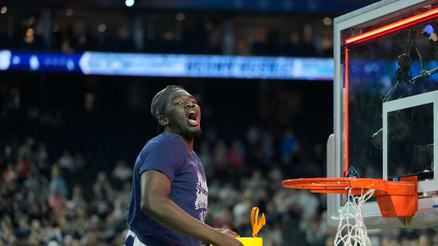 Apr 3, 2023; Houston, TX, USA; Connecticut Huskies forward Adama Sanogo (21) celebrates while cutting down the net after defeating the San Diego State Aztecs in the national championship game of the 2023 NCAA Tournament at NRG Stadium.