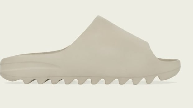 Side view of tan adidas Yeezy slide.