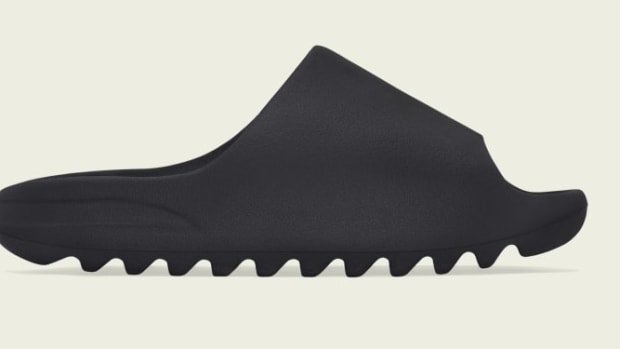 Side view of black adidas Yeezy slide.