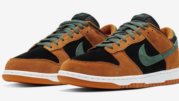 Side view of black, orange, and green Nike Dunk sneakers.