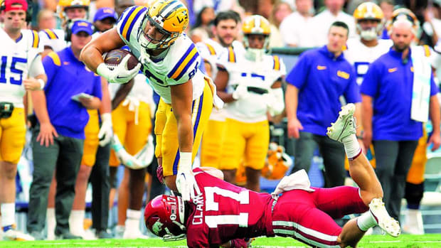 Arkansas defensive back Hudson Clark holds onto LSU tight end Mason Taylor for dear life in the first half of the game between the Razorbacks and Tigers in Baton Rouge.