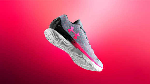 Side view of grey and pink Under Armour shoe.