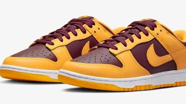 Side view of maroon and gold Nike Dunk shoes.