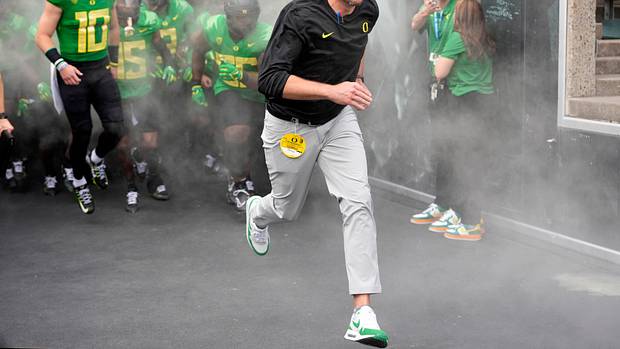 Oregon Ducks head coach Dan Lanning leads his team on the field prior to a game.