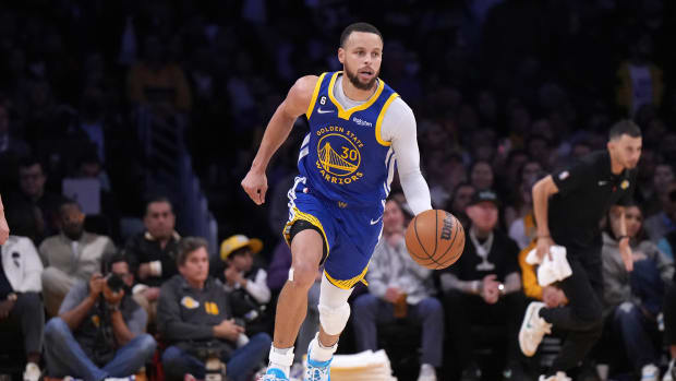 Golden State Warriors guard Stephen Curry dribbles the ball against the Los Angeles Lakers.