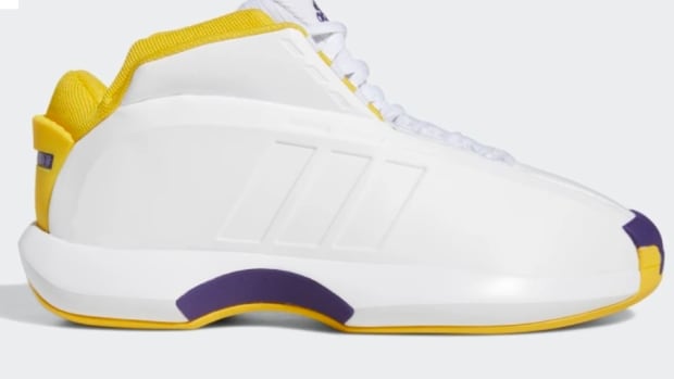 Side view of white, yellow, and purple adidas shoe.