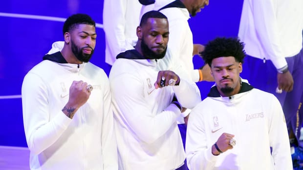 Los Angeles Lakers players Anthony Davis (left) and LeBron James (middle) and Quinn Cook (right) pose with 2020 NBA Championship rings before a game against the Los Angeles Clippers at Staples Center.