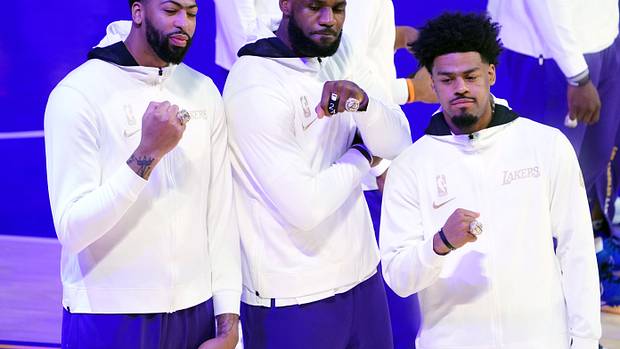 Los Angeles Lakers players Anthony Davis (left) and LeBron James (middle) and Quinn Cook (right) pose with 2020 NBA Championship rings before a game against the Los Angeles Clippers at Staples Center.