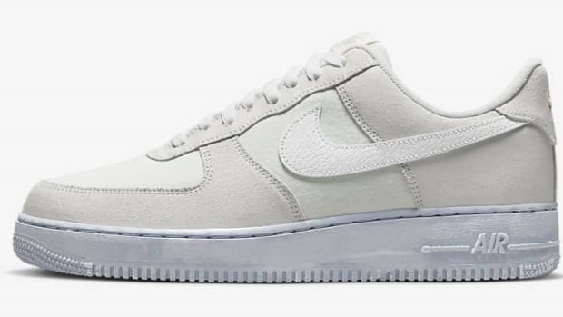 Side view of a white and grey Nike Air Force 1 shoe.