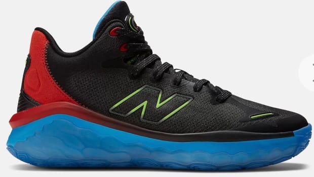Side view of black, red, and blue New Balance shoe.
