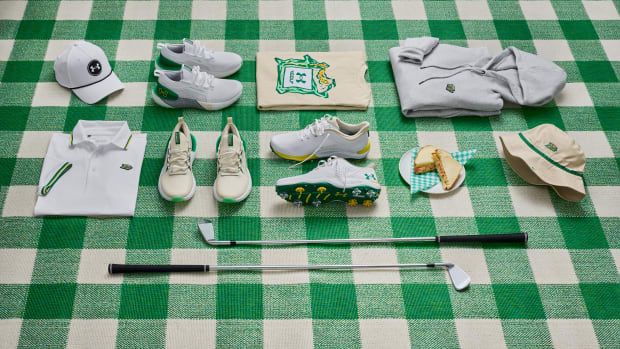 Under Armour apparel and shoes on a green blanket.