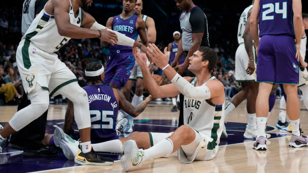 Milwaukee Bucks center Brook Lopez looks for a foul call as guard Jevon Carter helps him up during the first half against the Charlotte Hornets at the Spectrum Center.