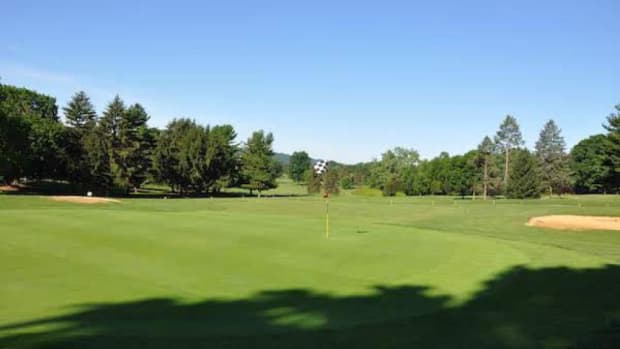 Looking back down the par-4 11th fairway, the hole bends and climbs to a sloped green. 