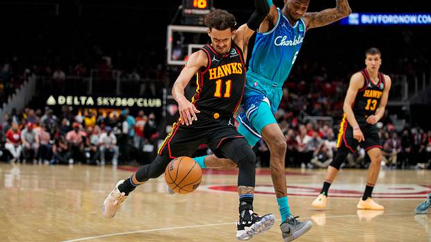 Hawks guard Trae Young pushes off Hornets forward Jalen McDaniels.