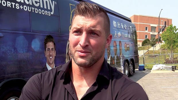 SEC Network host Tim Tebow hangs out by his bus before the show.
