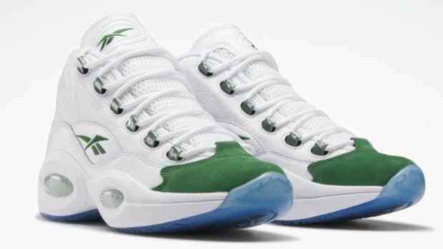 View ofwhite and green Reebok shoes.