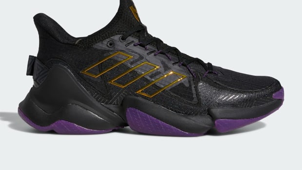 Side view of black and purple Adidas shoe.