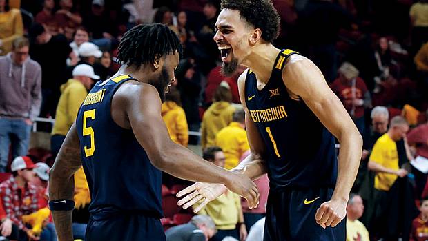West Virginia Mountaineers forward Emmitt Matthews Jr., guard Joe Toussaint celebrate after their win over the Iowa State Cyclones at James H. Hilton Coliseum.
